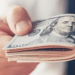 Financial loan, businessman offering US dollar paper currency ca